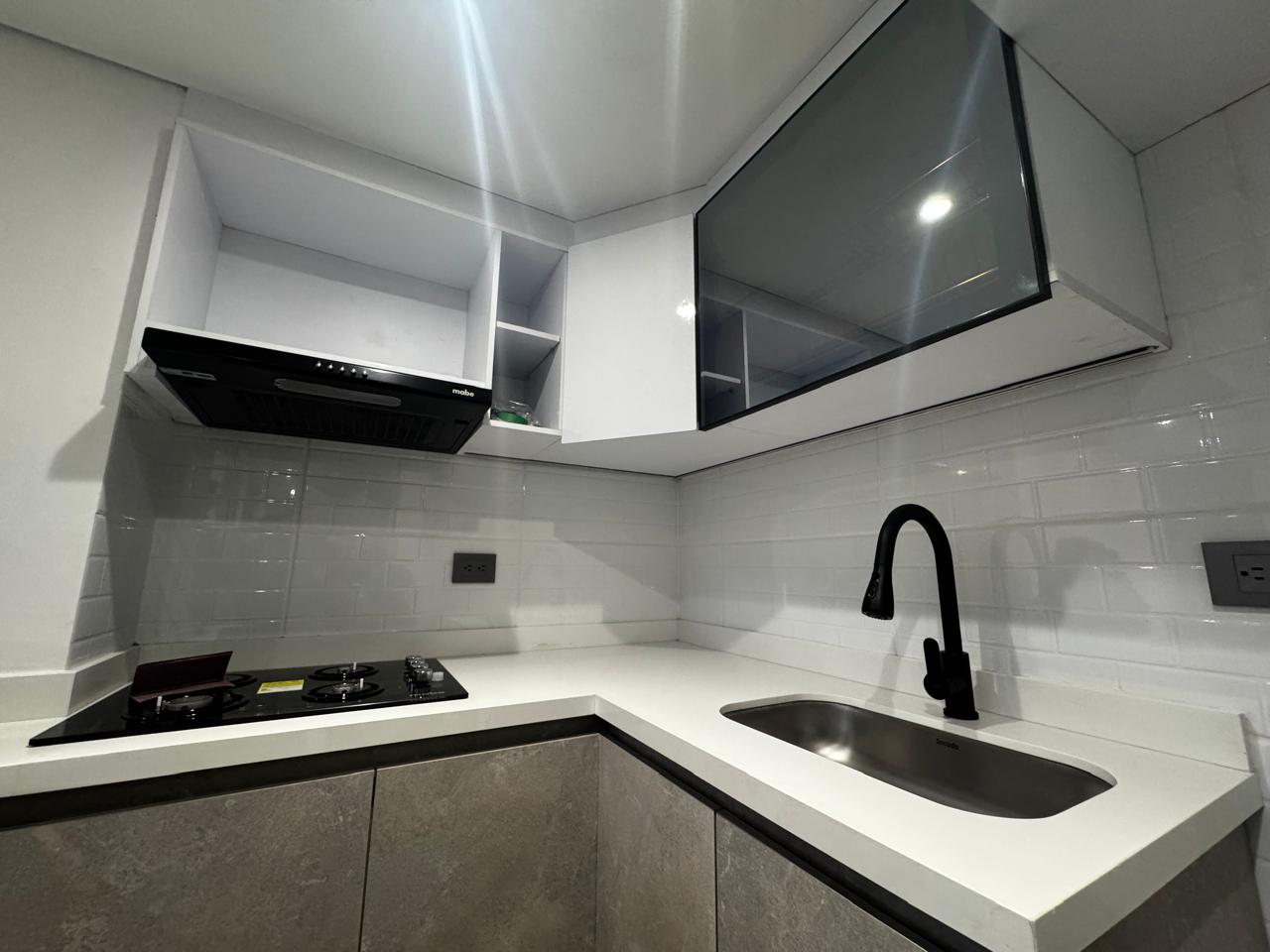 Cocina moderna con mesón blanco y grifería negra