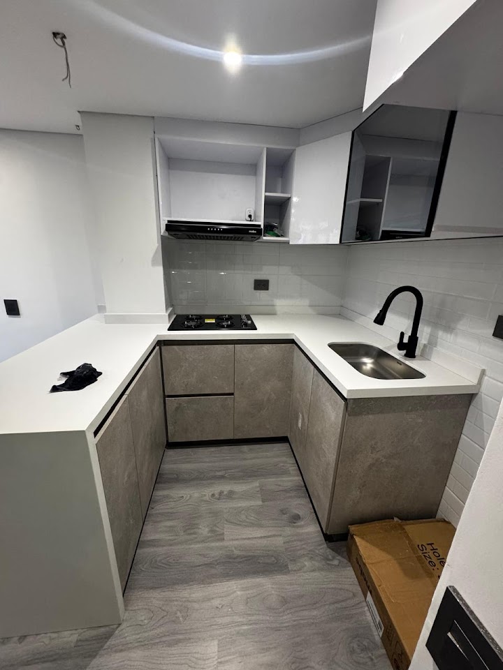 Cocina en L con mesón blanco y gabinetes grises